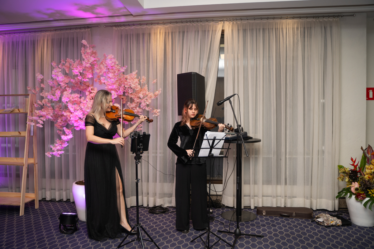 Duas violinistas se apresentam juntas durante momento musical do WEEM Talks 2026.